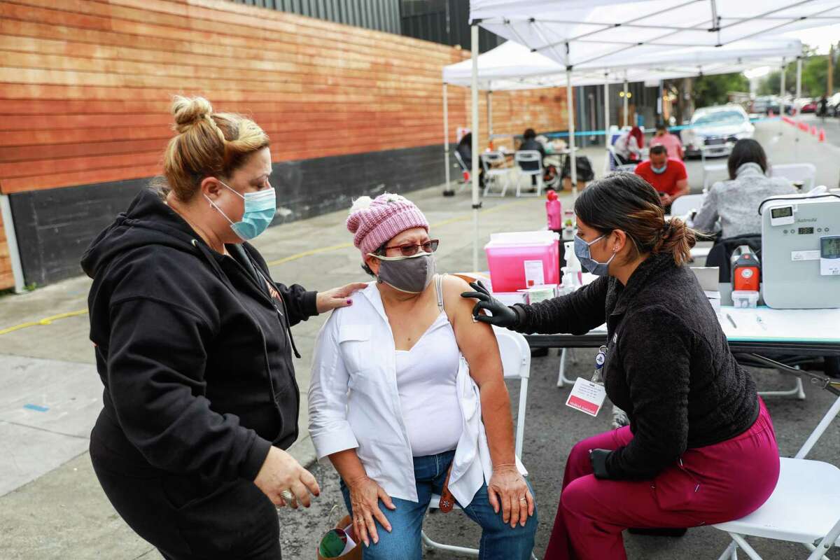 Carranza Domingo prepares to get the COVID-19 vaccination at the Latino Task Force pop-up in San Francisco. City health are now urging anyone 18 and over to get a booster shot.