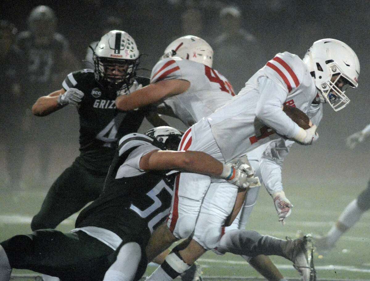 Ian Myers (50) of Guilford tackles Nathan Florio (4) of Branford on Friday night.