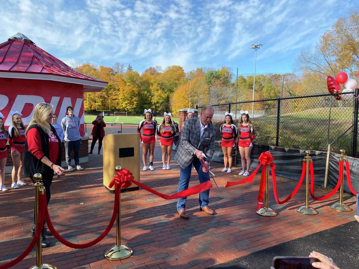 Board of Education member Joe Kelly cuts the ribbon for the official grand reopening of Cardinal Stadium at Greenwich High School Saturday, Nov. 13, 2021. Work still needs to be done on the visitors side of the stadium, and a new access road could be spun off into a separate project.