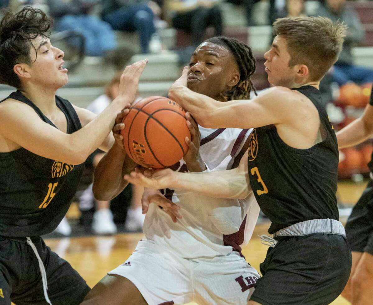 Legacy High's Elijah Maxwell gets fouled as he drives the lane by Seminole's Josh Lopez and Hudson Harper 11/13/2021 at Legacy High gym. Tim Fischer/Reporter-Telegram