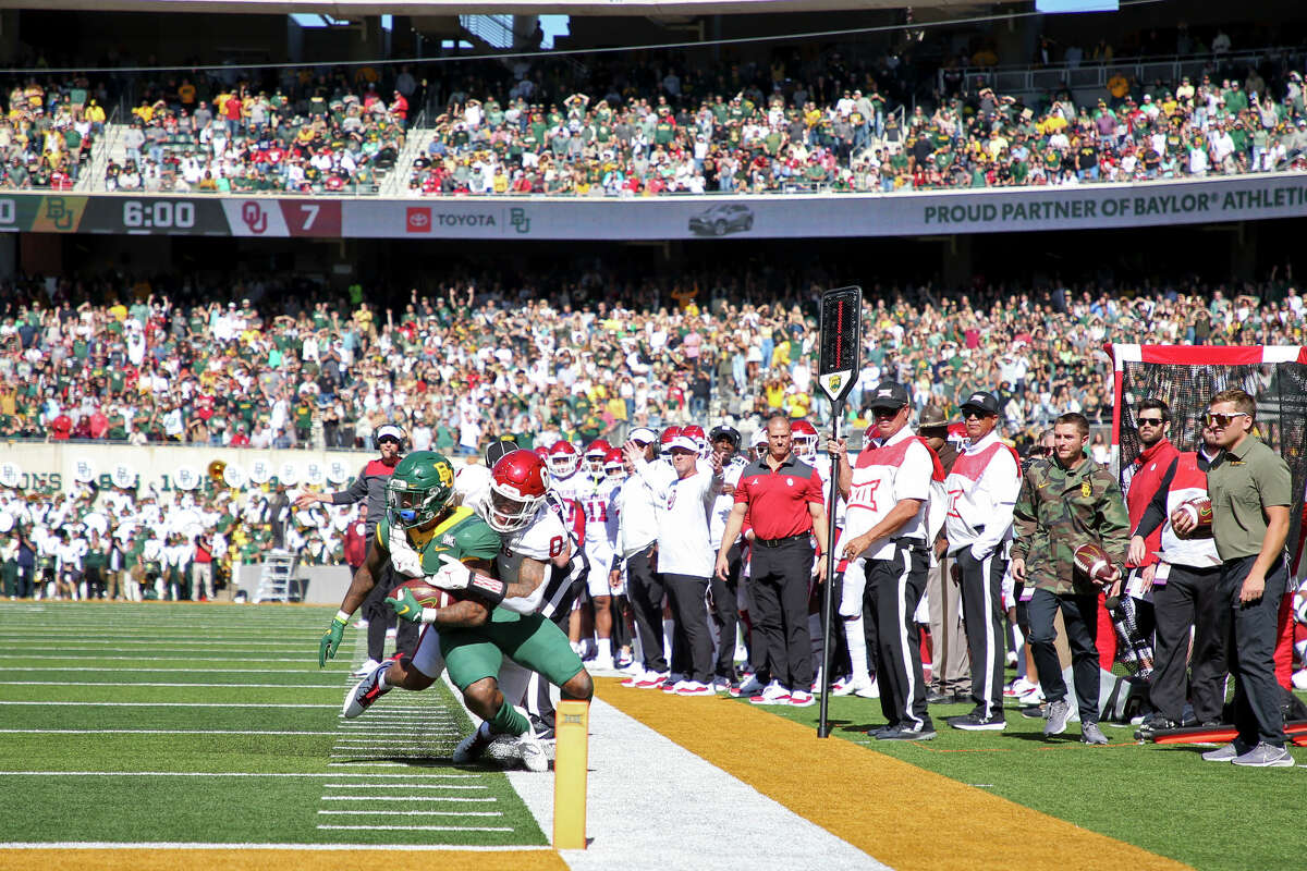 Oklahoma cornerback Woodi Washington (0) tackles Baylor running back Abram Smith (7) short of the goal line during a NCAA football in Waco, Texas on Saturday, Nov. 13, 2021. (Ian Maule/Tulsa World via AP)