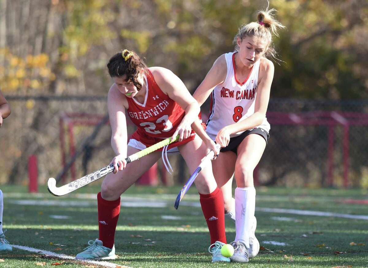 Greenwich’s Megan Young (23) and New Canaan’s Izzy Schuh (8) battle for the ball.