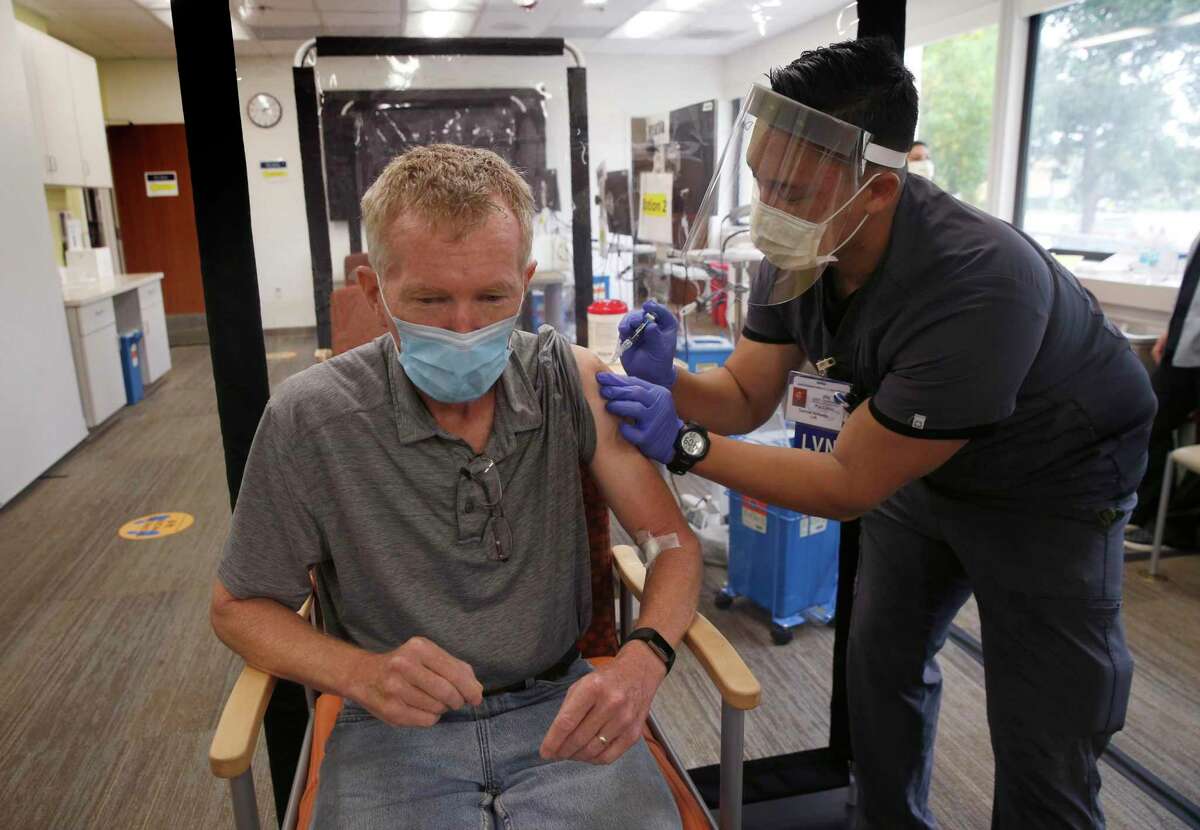 Damiel Amores administers a flu vaccine to Daniel Fitzpatrick at the Kaiser Permanente medical center in Redwood City last year. Kaiser reached a union deal Saturday, averting a planned strike.