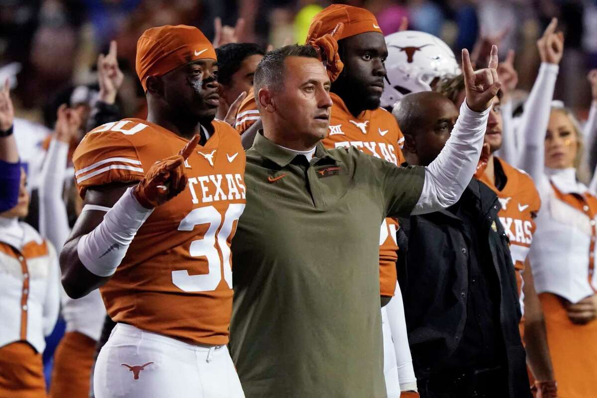 Texas coach Steve Sarkisian, center, stands with linebacker Devin Richardson (30) as they sing "The Eyes of Texas" after a 57-56 loss to Kansas on overtime in an NCAA college football game in Austin, Texas, Saturday, Nov. 13, 2021. (AP Photo/Chuck Burton)