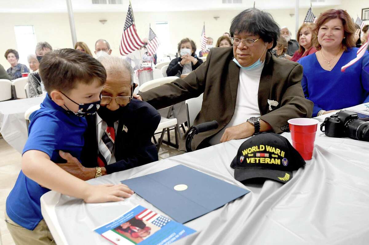 WWII veteran Patrick Aguilar gets a hug from his grandson "little Patrick" during a ceremony held at Our Lady of Guadalupe Church in Port Arthur Sunday. The public event was sponsored by Lamar Uniiversity's history department and the Center for History and Culture of Southeast Texas and the Upper Gulf Coast. Its spirit was to honor Aguilar for his service and to raise awareness of the contribution members of the local Mexican-American community made to serve the nation. Photo made Sunday, November 14, 2021 Kim Brent/The Enterprise