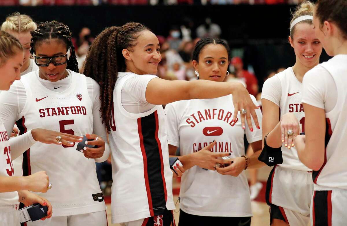 Stanford's Haley Jones (center) and Lexie Hull (right) show off their National Championship rings during ceremony following 61-56 loss to Texas in women's college basketball game at Maples Pavilion in Stanford, Calif., on Sunday, November 14, 2021.