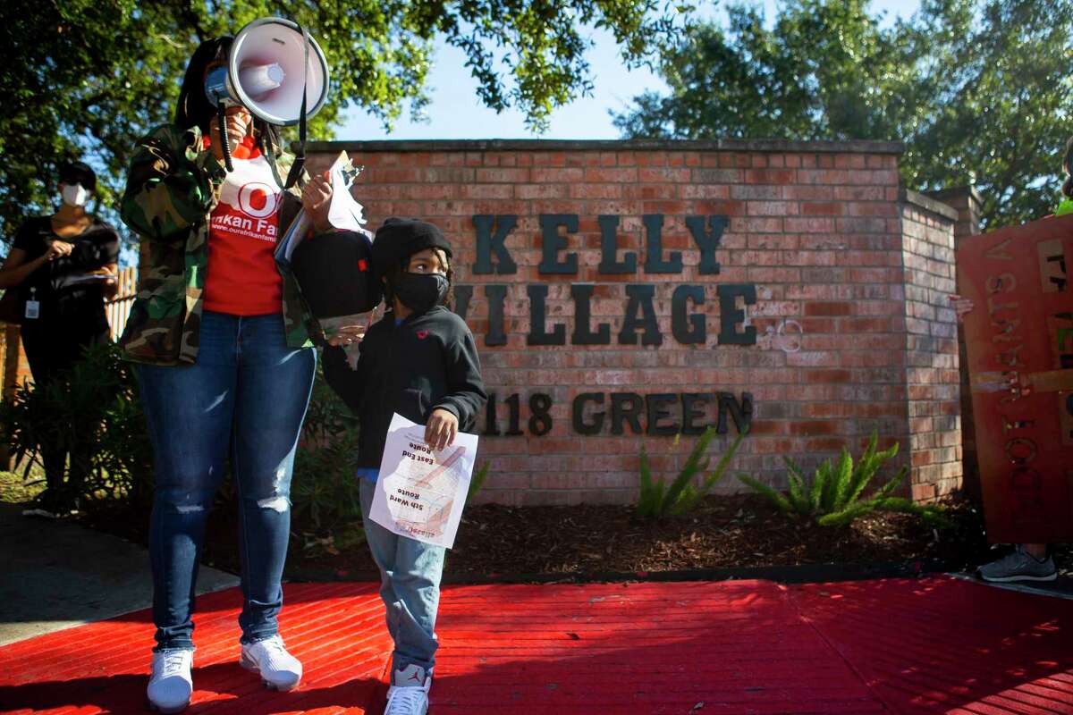 Kendra London and her five year old son, Shahid, lead a tour beginning at the Kelly Village apartments during a protest walk in Fifth Ward of the proposed Interstate 45 widening on Dec. 6, 2020.