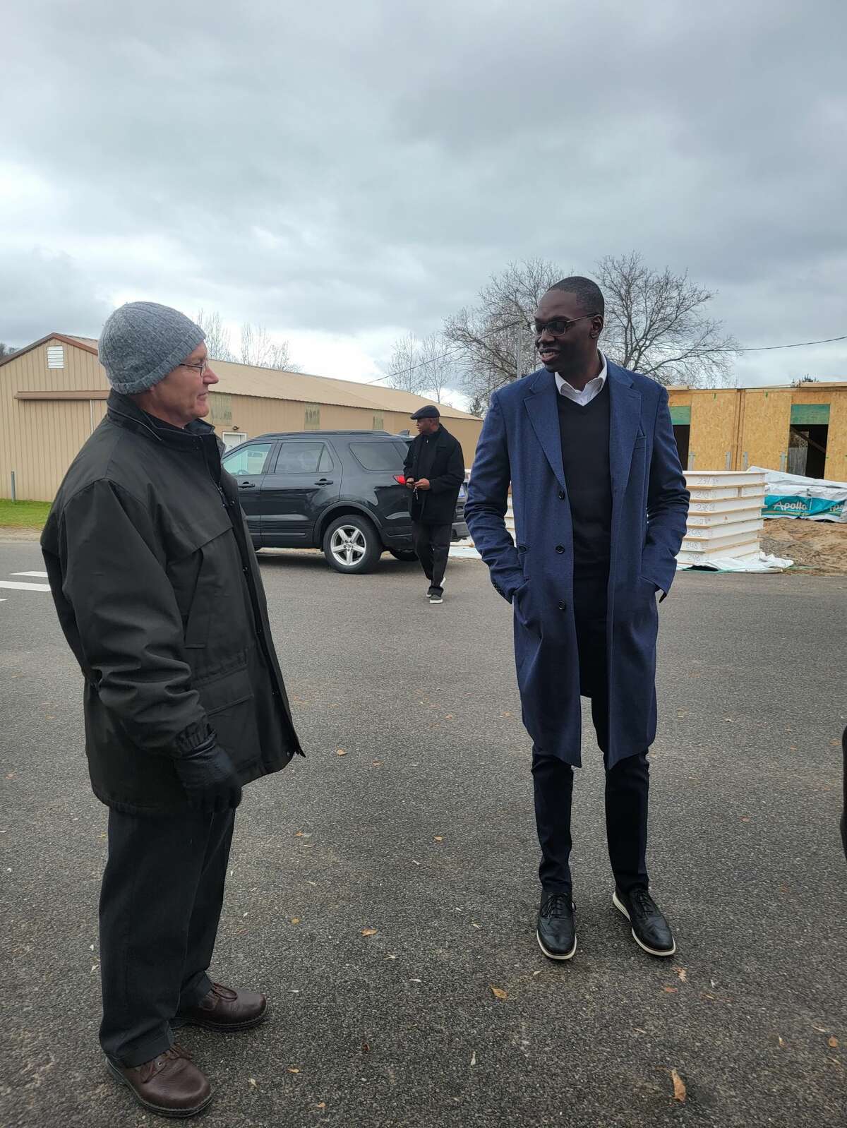 Lt. Gov. Garlin Gilchrist talks with Jonathan Stimpson, executive director of Homestretch, the nonprofit building eight housing units in Honor. 