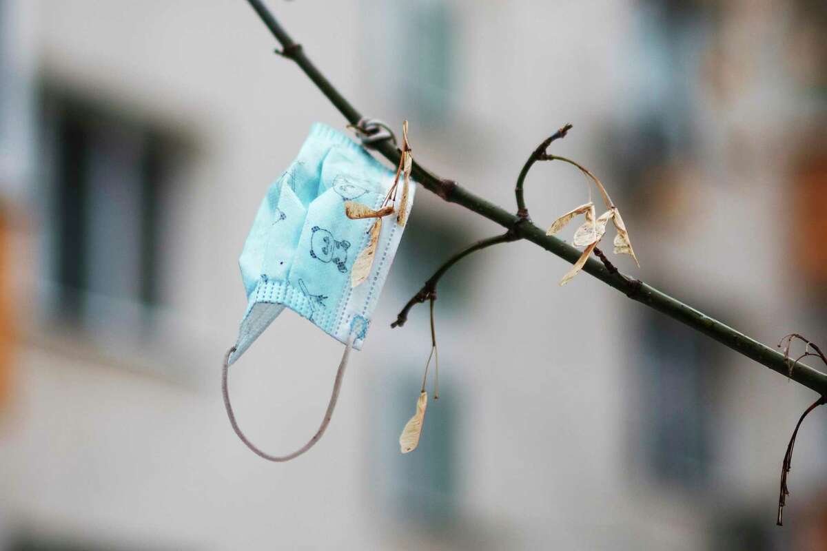 A face mask hangs on a tree in Moscow, Russia, Friday, Nov. 12, 2021. Russian authorities say they are preparing new restrictions to counter the unrelenting surge of coronavirus infections that has engulfed the vast country in recent weeks. (AP Photo/Pavel Golovkin)