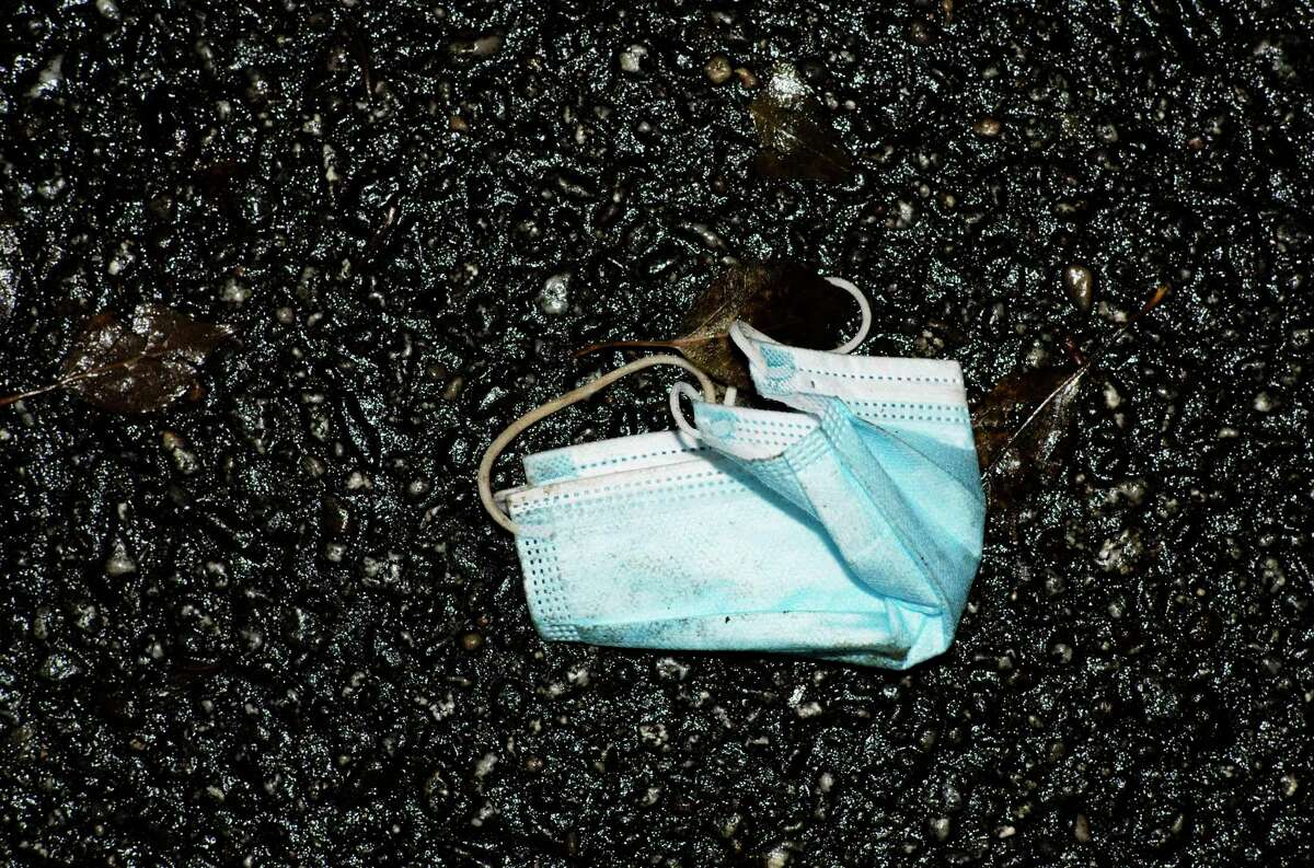 A used face mask is left on a street in Berlin, Germany, Friday, Nov. 12, 2021. Germany battles a fourth wave of the coronavirus with high number of infections in the recent days. (AP Photo/Markus Schreiber)
