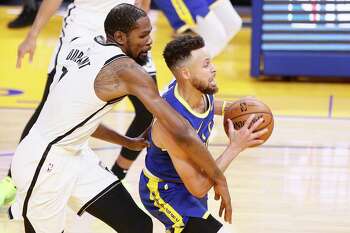 Golden State Warriors guard Stephen Curry (30) drives to the hoop defended by Brooklyn Nets forward Kevin Durant (7) in the third quarter of an NBA game at Chase Center, Saturday, Feb. 13, 2021, in San Francisco, Calif.