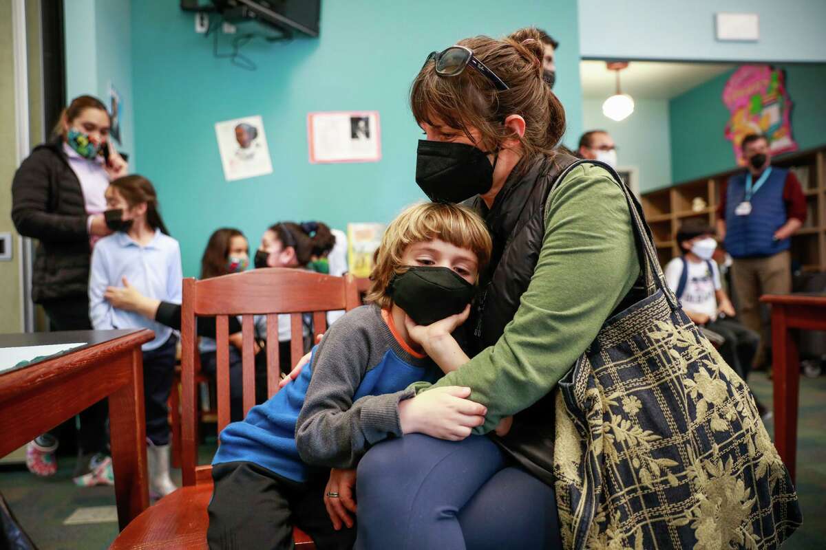 Dominick Knight, 5, rests on mom Paige Tomaselli before his COVID-19 vaccine this month, with 5-year-olds finally eligible.