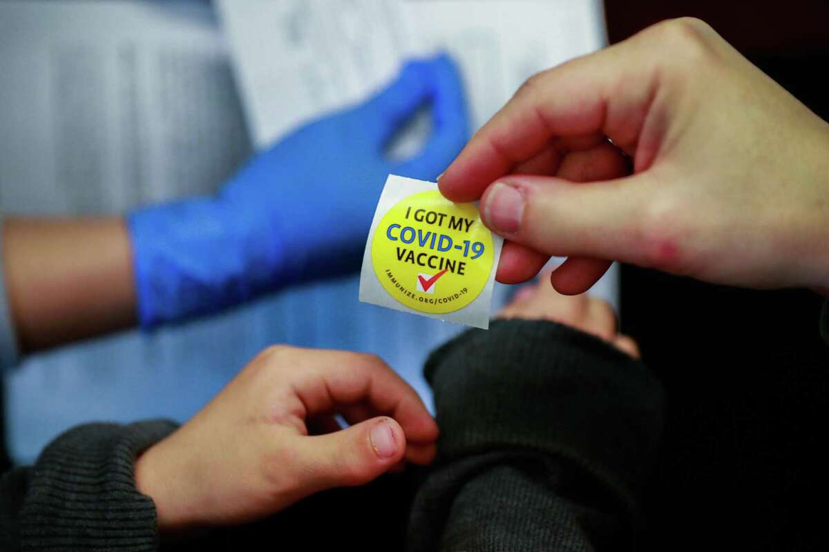 mom Paige Tomaselli (right) gives son Dominic Knight, 5, (left) a sticker after he got the COVID-19 vaccine on Tuesday, Nov. 9, 2021 in Richmond, California.