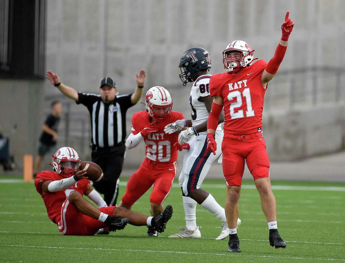 Katy linebacker Carson Marshall (21) celebrates Arian Parish’s, bottom left, interception during the first half of a high school football game against Tompkins, Friday, Oct. 1, 2021, in Katy.