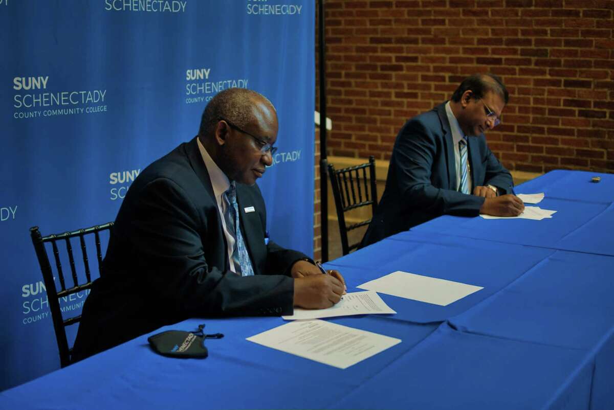 Steady Moono, left, president of SUNY Schenectady, and Paul Dhinakaran, chancellor of Karunya Institute of Technology and Sciences in India, sign a Memorandum of Understanding to develop academic and educational cooperation between them at an event at SUNY Schenectady on Tuesday, Nov. 16, 2021, in Schenectady, N.Y.