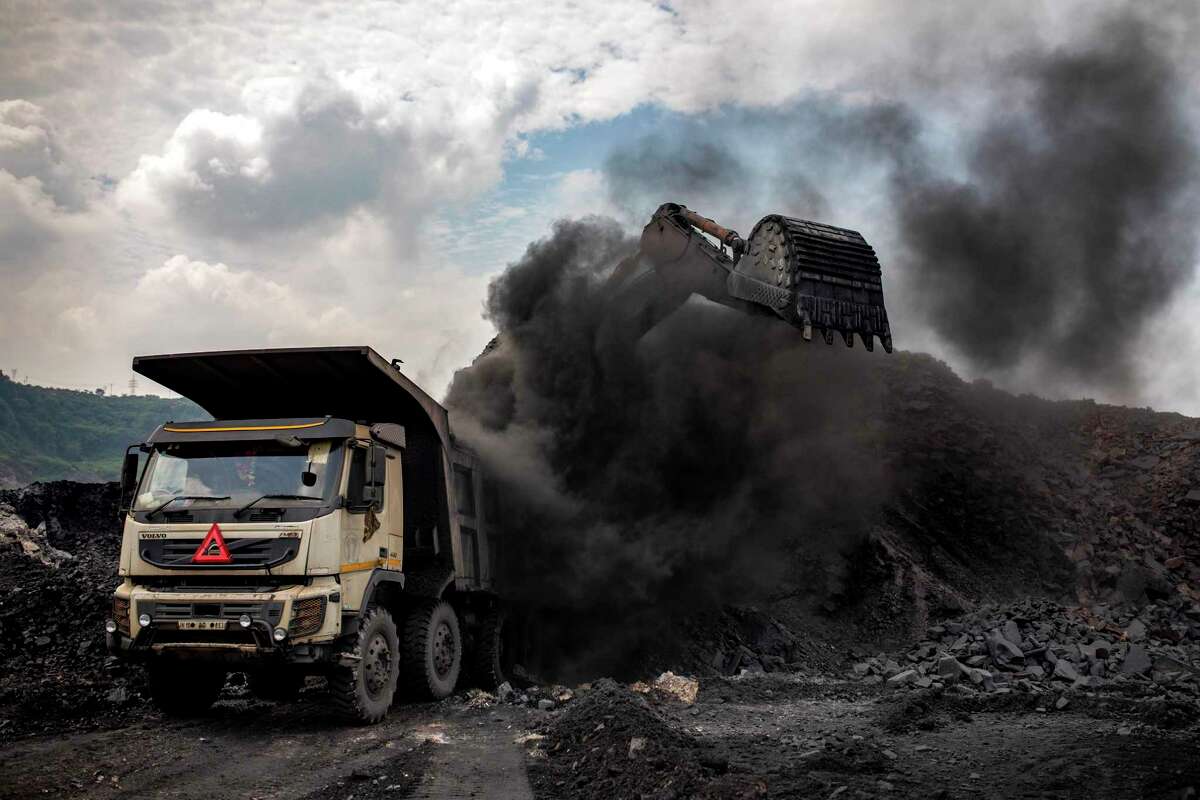 Coal is loaded into a truck at an open-cast mine near Dhanbad, an eastern Indian city in Jharkhand state, Friday, Sept. 24, 2021. On Saturday, India asked for a crucial last minute-change to the final agreement at crucial climate talks in Glasgow, calling for the "phase-down" not the "phase-out" of coal power. (AP Photo/Altaf Qadri)