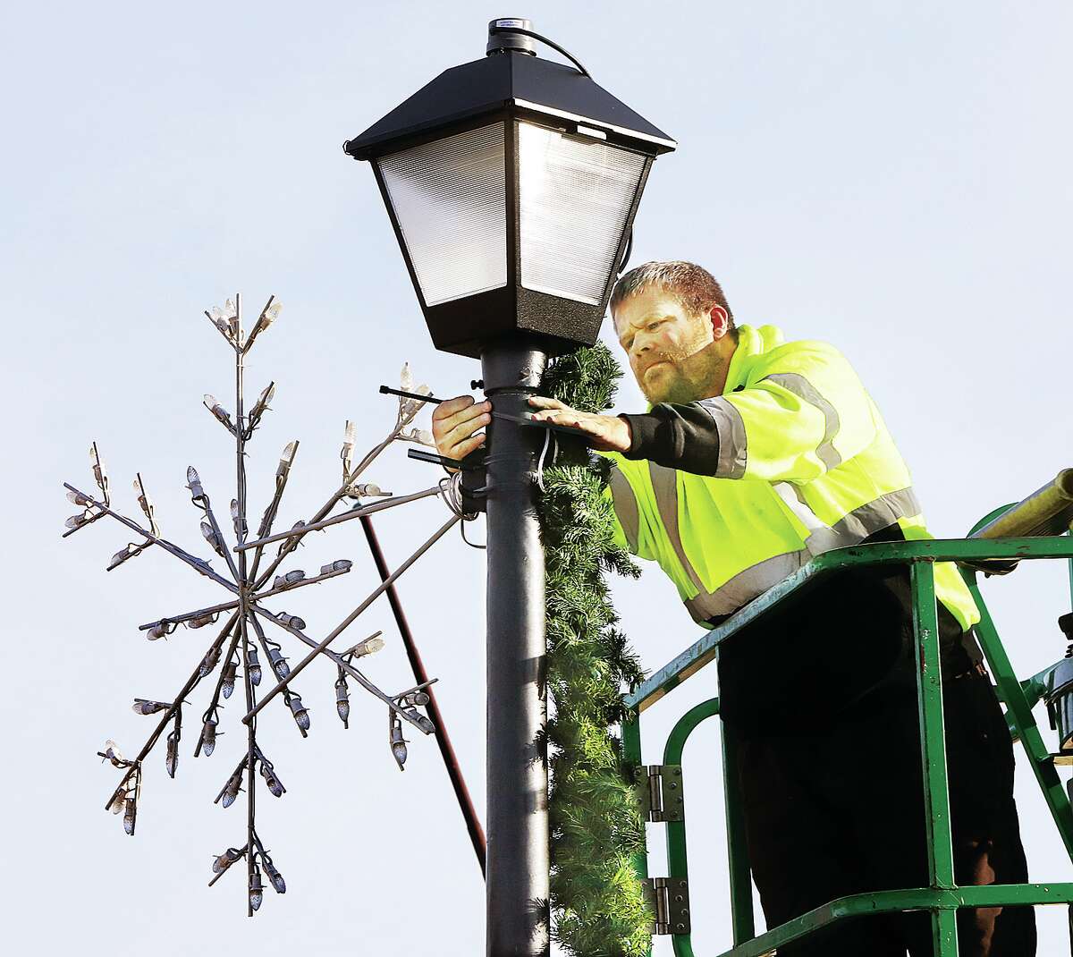 John Badman|The Telegraph Wood River Public Works employees took advantage of Tuesday's warm weather to finish hanging Christmas decorations in the downtown area, like here at Ferguson Avenue and 2nd Street.