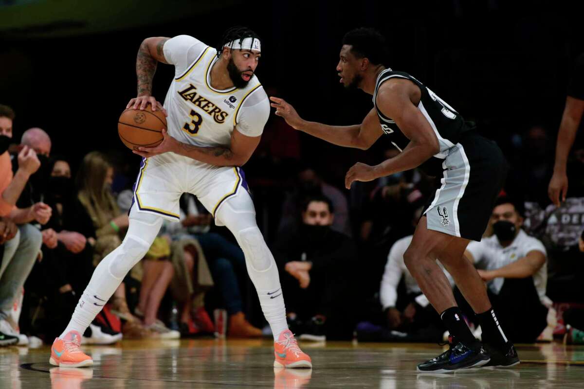 Los Angeles Lakers forward Anthony Davis (3) looks for an opening with pressure from San Antonio Spurs forward Thaddeus Young, right, during the second half of an NBA basketball game Sunday, Nov. 14, 2021, in Los Angeles.