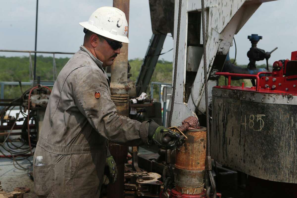 Roughneck Eluid Cervantes lubricates a section of drilling pipe Thursday May 11, 2017 at the Abraxus Petroleum Shut Eye Unit oil drilling rig in the Eagle Ford Shale in Atascosa County.