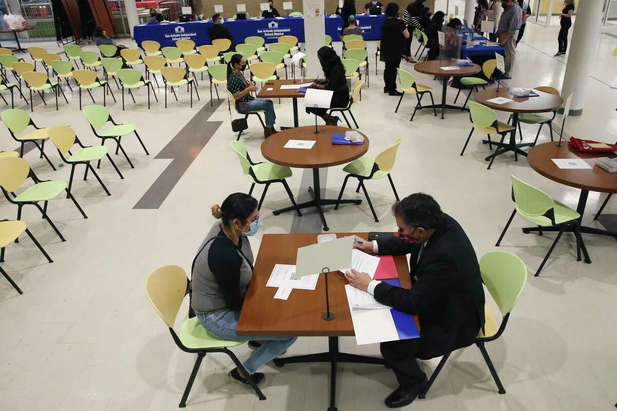 Prospective substitute teachers are interviewed at a San Antonio ISD job fair at Sam Houston High School last month. The SAISD board Monday voted to continue to require mask-wearing at schools.