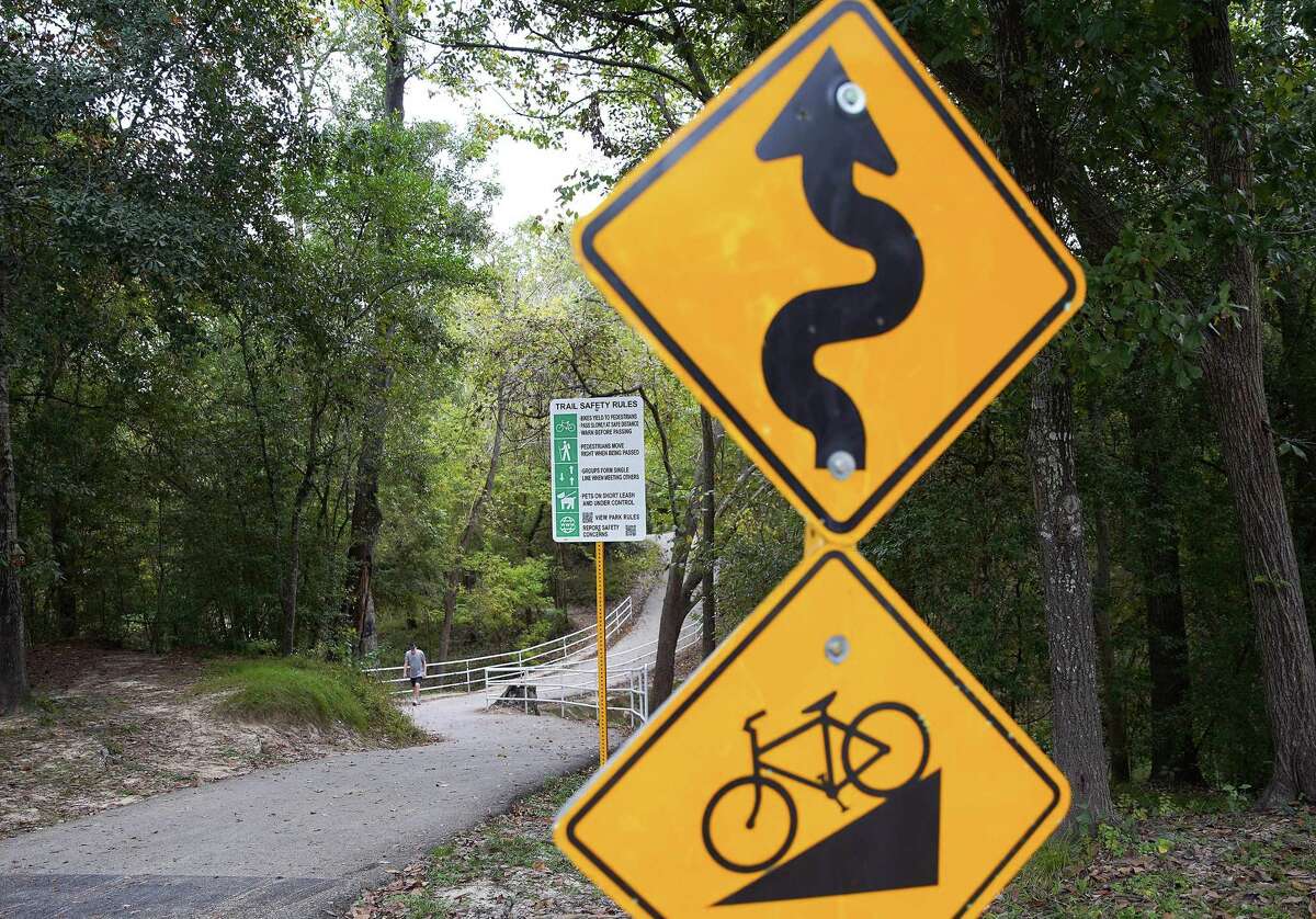A pedestrian walks on the Terry Hershey trail in Houston on Oct. 26, 2021. The signs of the trail recently changed from speed limits for cyclists to more inclusive signage on trail etiquette.