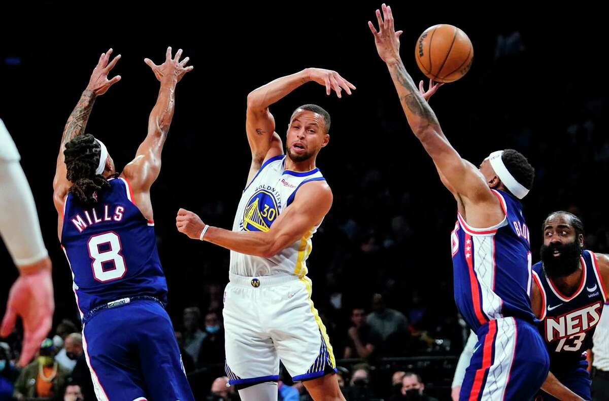 Stephen Curry eludes Patty Mills (8) and Bruce Brown in the first half of a Golden State drubbing. Curry finished with 37 points and five assists.