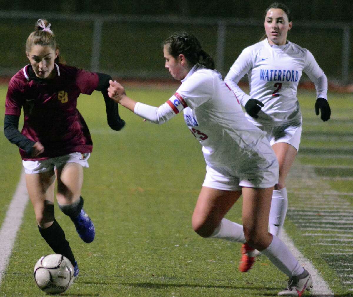 St. Joseph's Sara Parker dribbles the ball downfield during the CIAC Class L girls' soccer semifinals Tuesday night at Strong Stadium in West Haven. Waterfird's Lily Marelli defends.