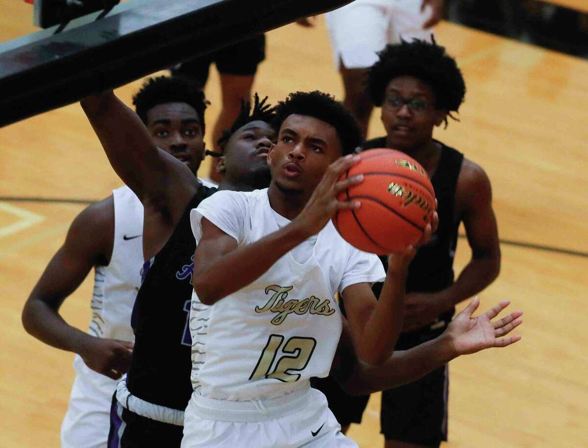 Conroe point guard Nigel Leday (12) draws contact as he shoots during the first quarter of a non-district high school basketball game at Conroe High School, Tuesday, Oct. 16, 2021, in Conroe.