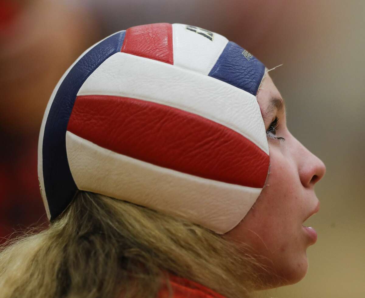 The Woodlands'  Olivia Chojnacki (7) wears a volleyball as heargear during the third set of a high school volleyball match at The Woodlands High School, Tuesday, Sept. 28, 2021, in The Woodlands.