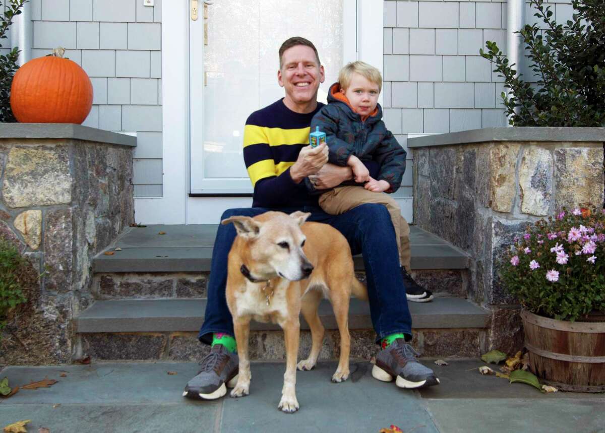 Dan Guller, who is organizing the first-ever Darien community menorah lighting in December, following recent incidents of anti-Semitism, poses at home with his son Eli, 3, and dog Anya on Tuesday.