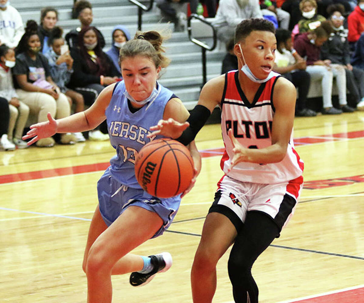 Jersey's Cate Breden (left) tips the ball away from Alton's Khaliyah Goree on a fast break during the Redbirds' girls basketball victory in the Alton Tourney on Tuesday night in Godfrey.
