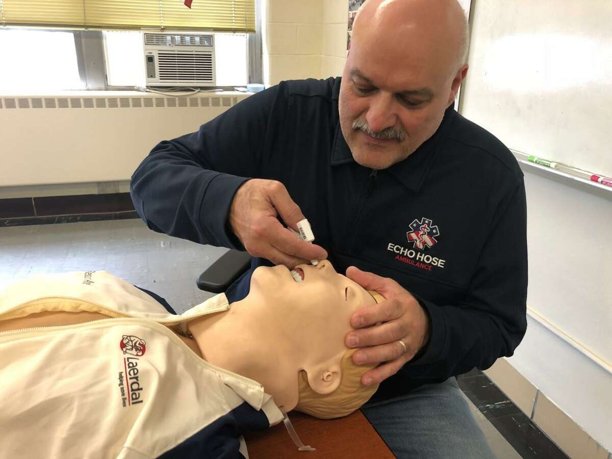Patrick Lahaza, education and paramedic coordinator at Echo Hose Ambulance Corps, in Shelton, Conn., demonstrates the proper use of Narcan nasal spray.