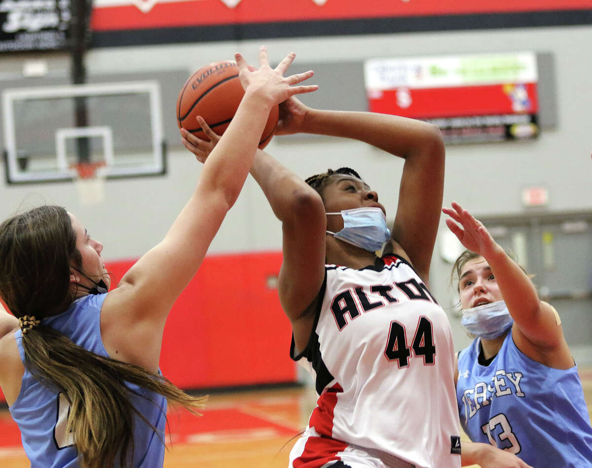 Alton's Jarius Powers (33) puts up a shot between Jersey's Avery Reeder (left) and Cate Breden during a girls basketball game in the Alton Tourney on Tuesday night in Godfrey.