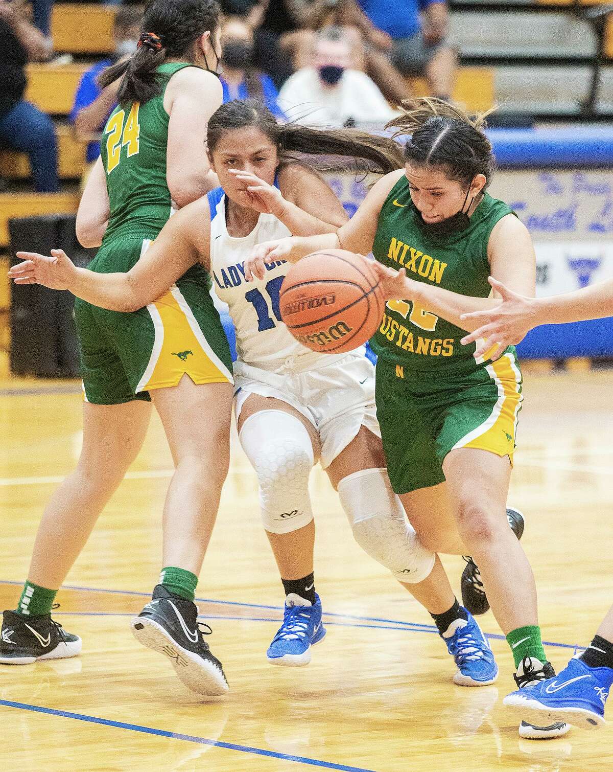 Cigarroa High School’s Alexis Ramirez fights through a pick as Nixon High School Danica Robles drives toward the basket.