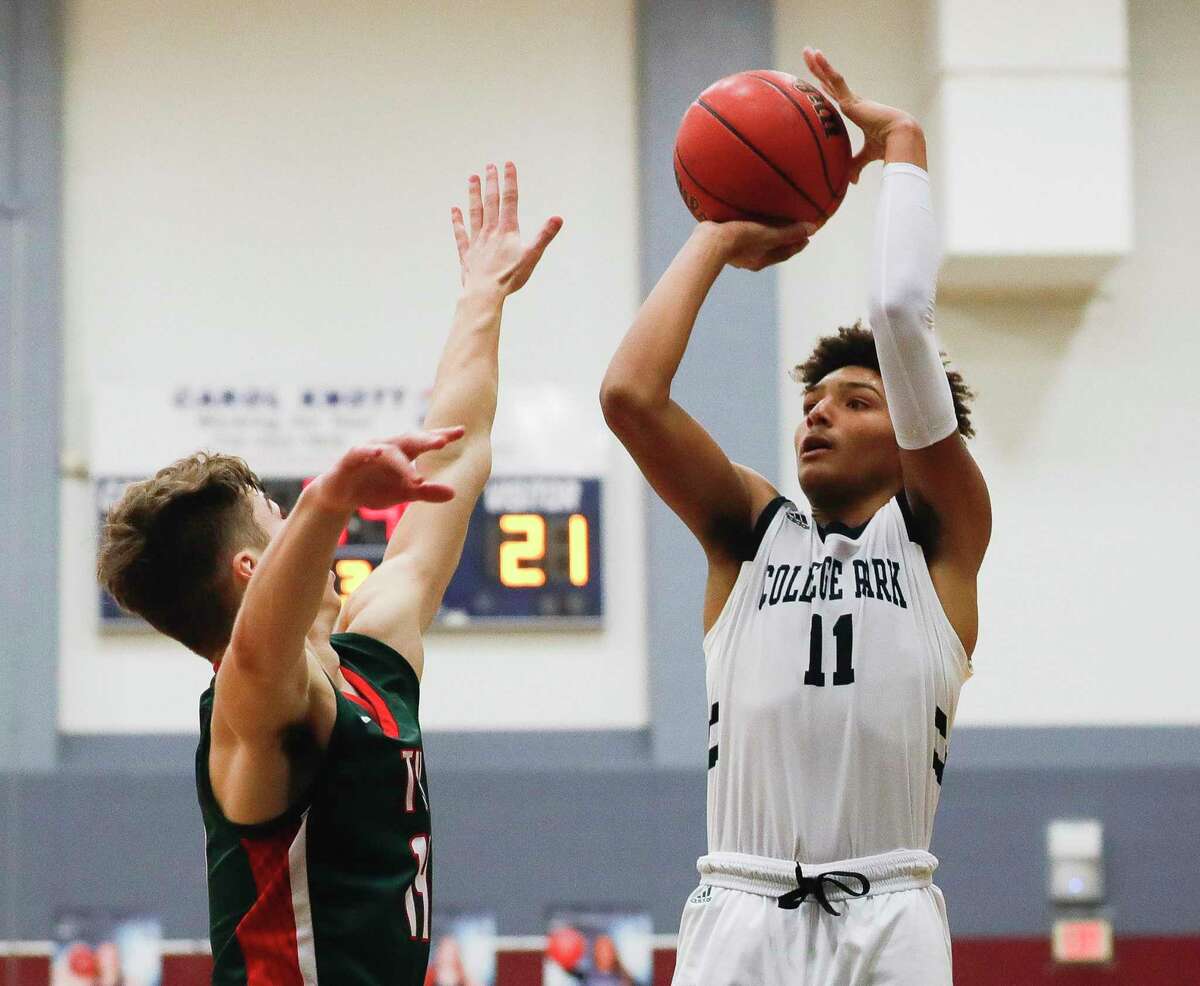 College Park guard Ty Buckmon (11) shoots a 3-pointer over The Woodlands guard Isaiah Brown (14) during the second quarter of a District 15-6A high school basketball game at College Park High School, Saturday, Jan. 23, 2021, in The Woodlands.