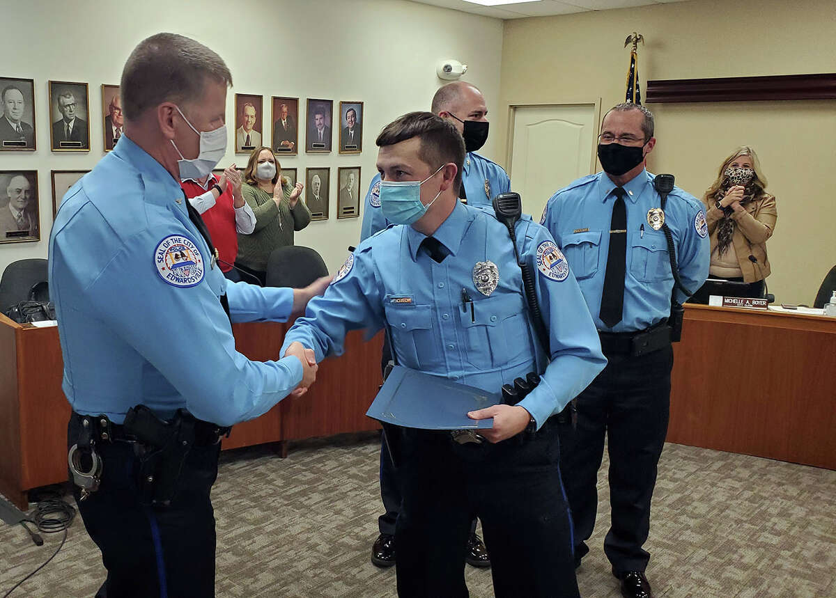 Police Chief Michael Fillback, left, congratulates Ofc. Jacob Welch Tuesday after Welch receives the Meritorious Service Award during a city council meeting. 