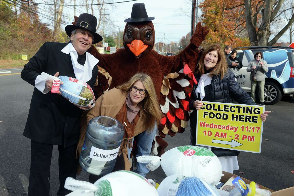 Dr. Bruce Sofferman, his daughter Sophia, wife Deborah and Brendan Carey dressed as a turkey, during the annual Thanksgiving food collection in front of Smile Dental Center in Shelton on Wednesday.