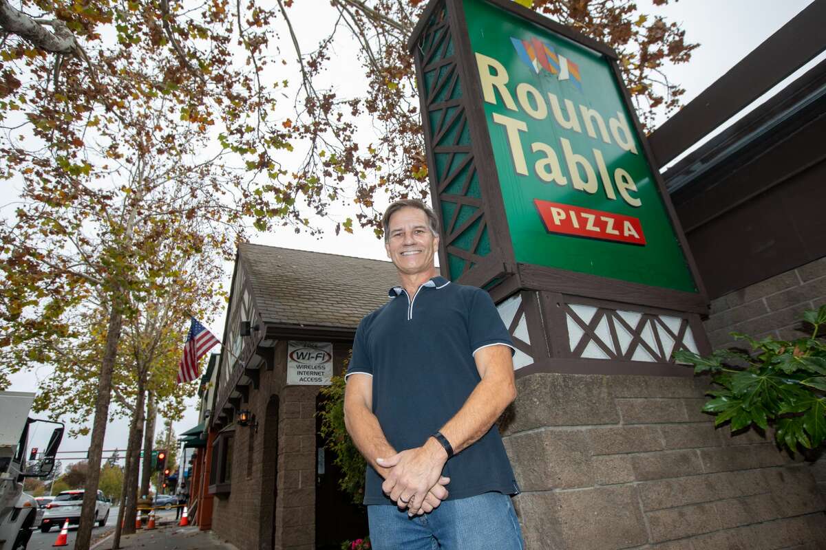 Owner Bob Larson stands outside at the original Round Table Pizza restaurant in Menlo Park, Calif., on Nov. 17, 2021. His father Bill was the founder of the pizza chain.