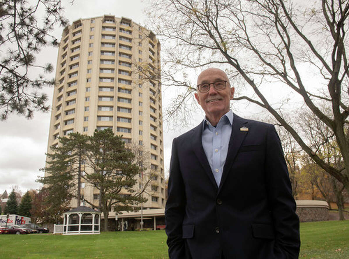 Duncan Barrett, a longtime developer of affordable housing, stands in front of Kennedy Towers, one of his proudest achievements on Tuesday, Nov. 16, 2021 in Troy, N.Y.