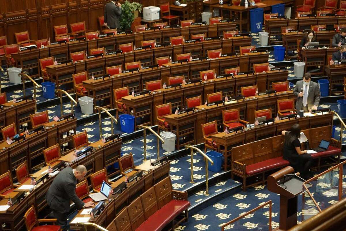 Social distancing: Rep. Craig Fishbein, left, and Rep. Steve Stafstrom debate a judicial reappointment in a House largely emptied due to the COVID-19.