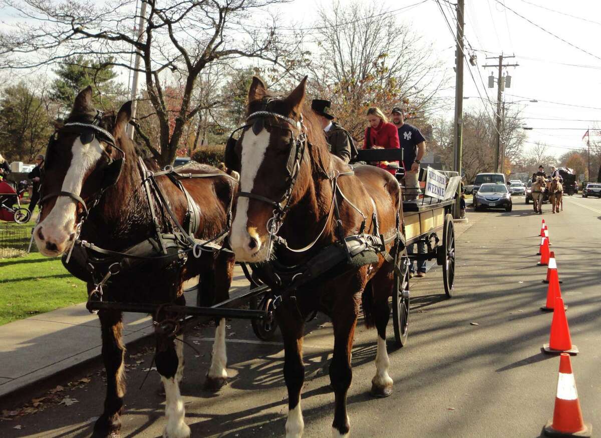 Two teams of horses from Allegra Farm in East Haddam previously take people on carriage rides in downtown Faifield, during a welcome for Santa Claus that was sponsored by the Fairfield Chamber of Commerce in a recent year. Santa Claus is returning to Fairfield at 10 a.m. where he will be until 2 p.m., all on Artists Sunday, Sunday, Nov. 28, after two years of not doing so because of the coronavirus pandemic.