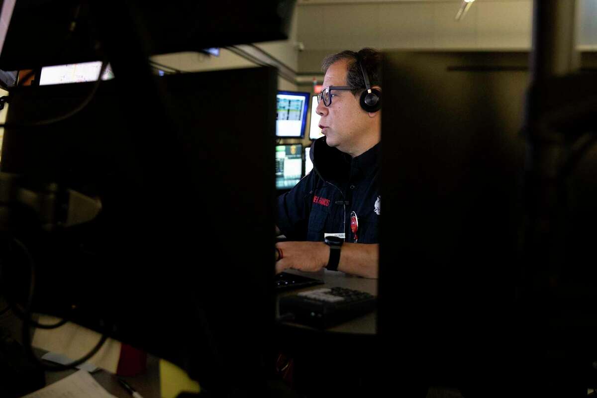 Ronnie Ramos, a communications dispatcher for SAFD, takes calls at the dispatch center.