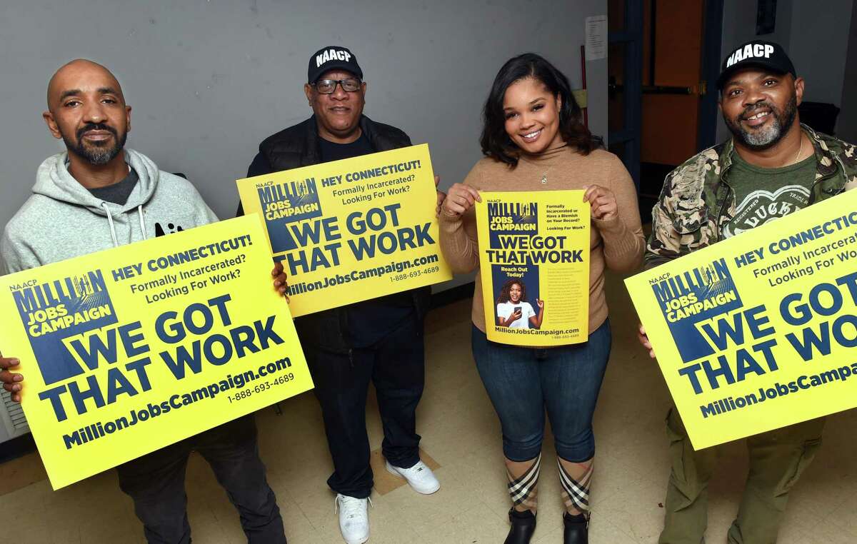 From left, Tyrone Whitaker, recently hired by Yale New Haven Hospital for patient transport, Connecticut NAACP President Scot X Esdaile, and community outreach workers Carli Knox and Corrie Betts are photographed in New Haven with signs advertising the NAACP Million Jobs Campaign on Nov. 12, 2021. Health services was one of the sectors that contributed to Connecticut’s gain of 5,300 jobs in October 2021.