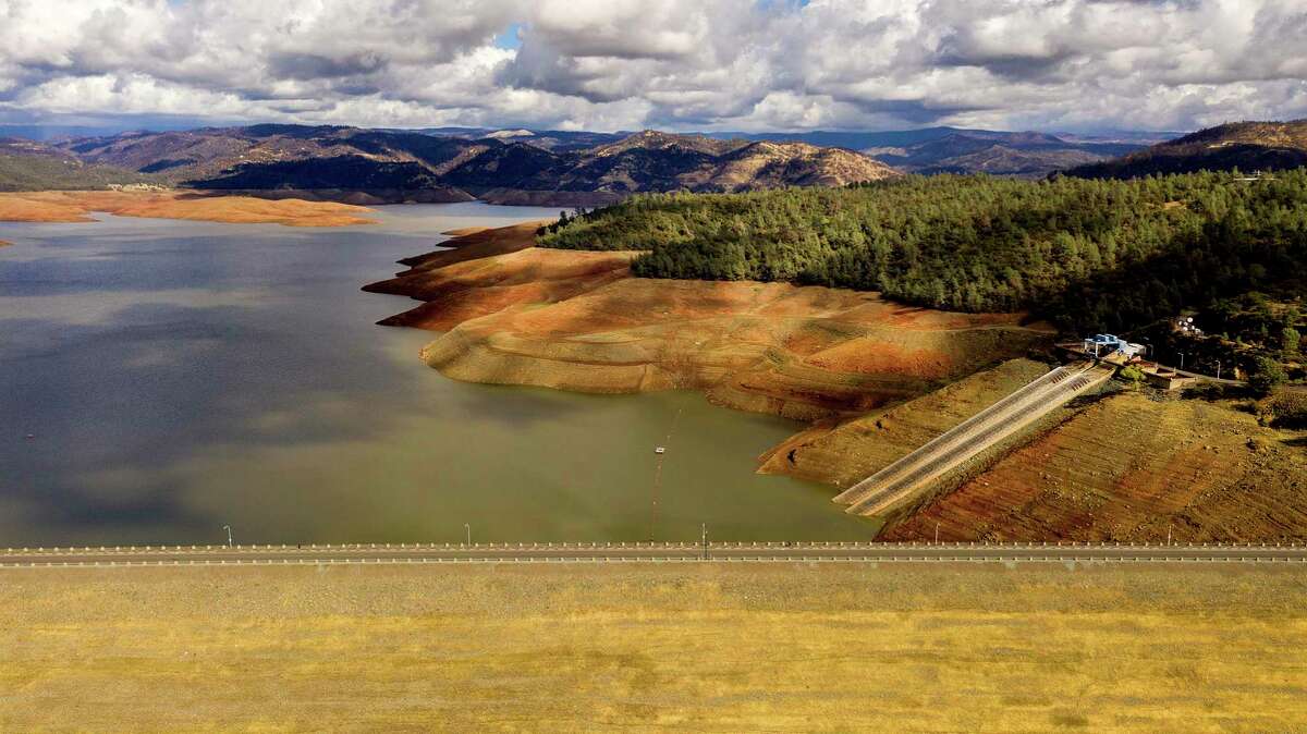 Clouds gather over Lake Oroville last month. Recent storms raised reservoir levels across the state but many still remain at or near historical lows — and the drought is projected to continue.