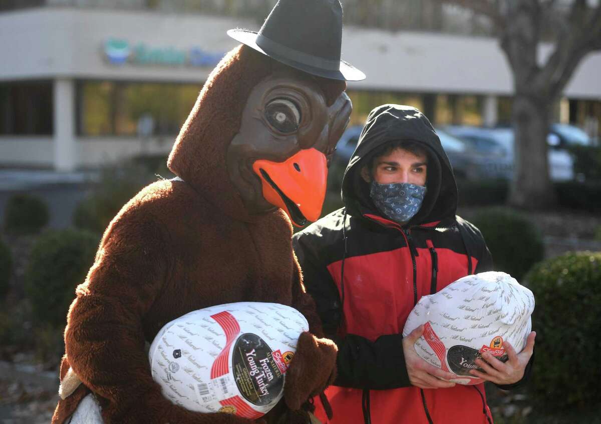Brendan Carey, left, of Shelton, and Christian DeRosa, of North Haven, carry donated Thanksgiving turkeys during the annual food donation for the Valley Food Bank on Bridgeport Avenue on Nov. 18, 2020.