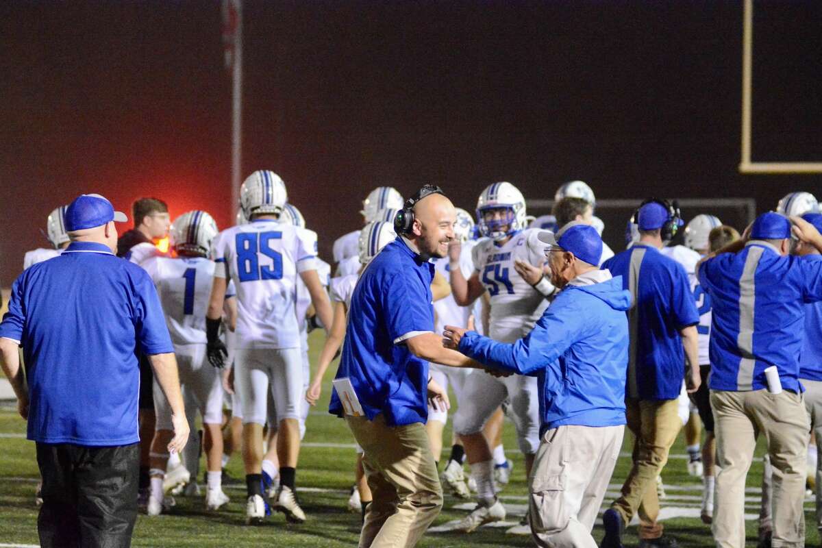 Gladwin coach Marc Jarstfer (with headset) is congratulated after his Flying G's beat Clare on Oct. 8, 2021.