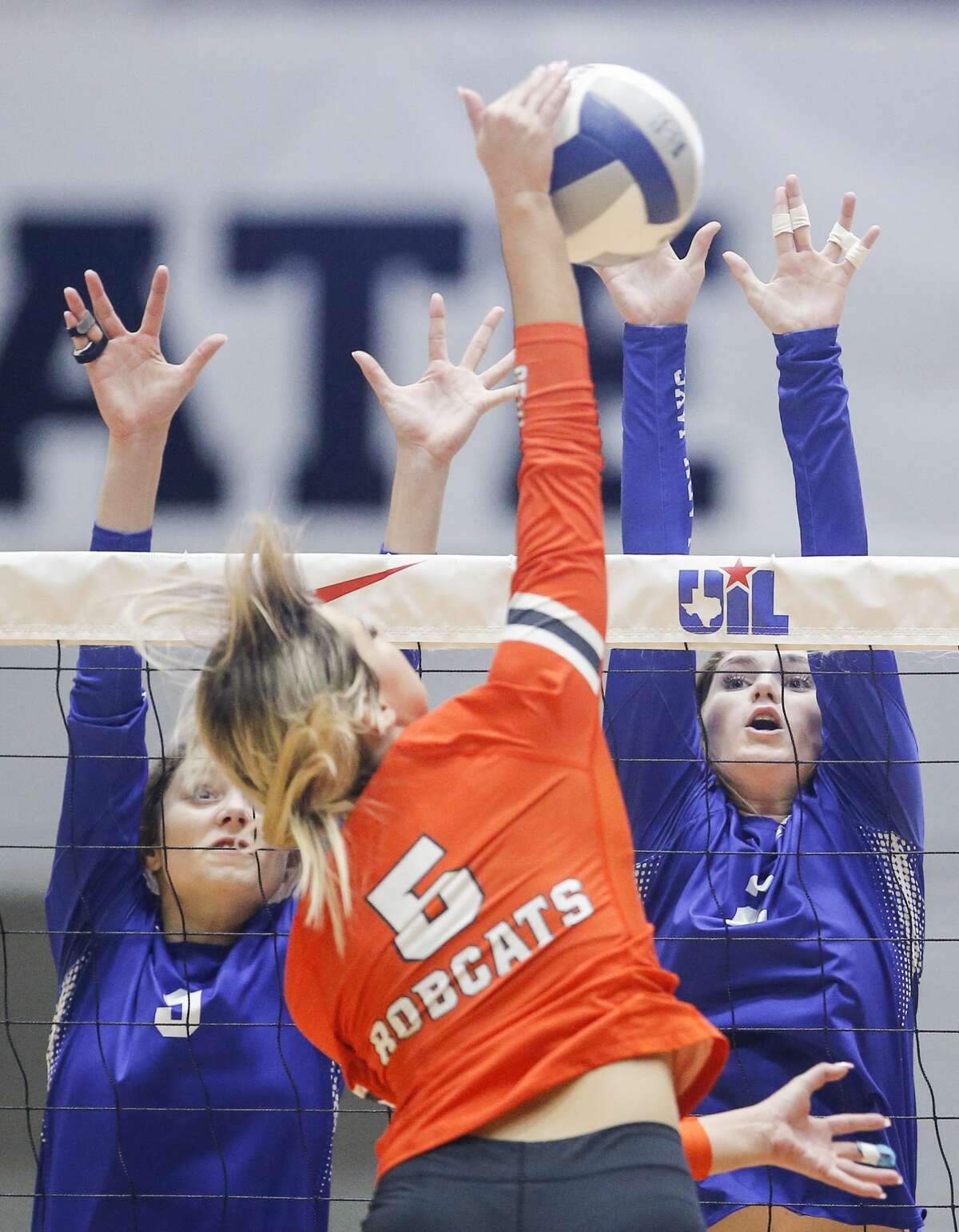 Celina senior Lexi Manning (5) spikes the ball as Needville seniors Ashley Fojtik (9) and Sarah Doggett (2) block during a high school Class 4A semifinals volleyball match, Thursday, November 18, 2021. Needville lost in three straight matches. Special to the Houston Chronicle/Brandon Wade.