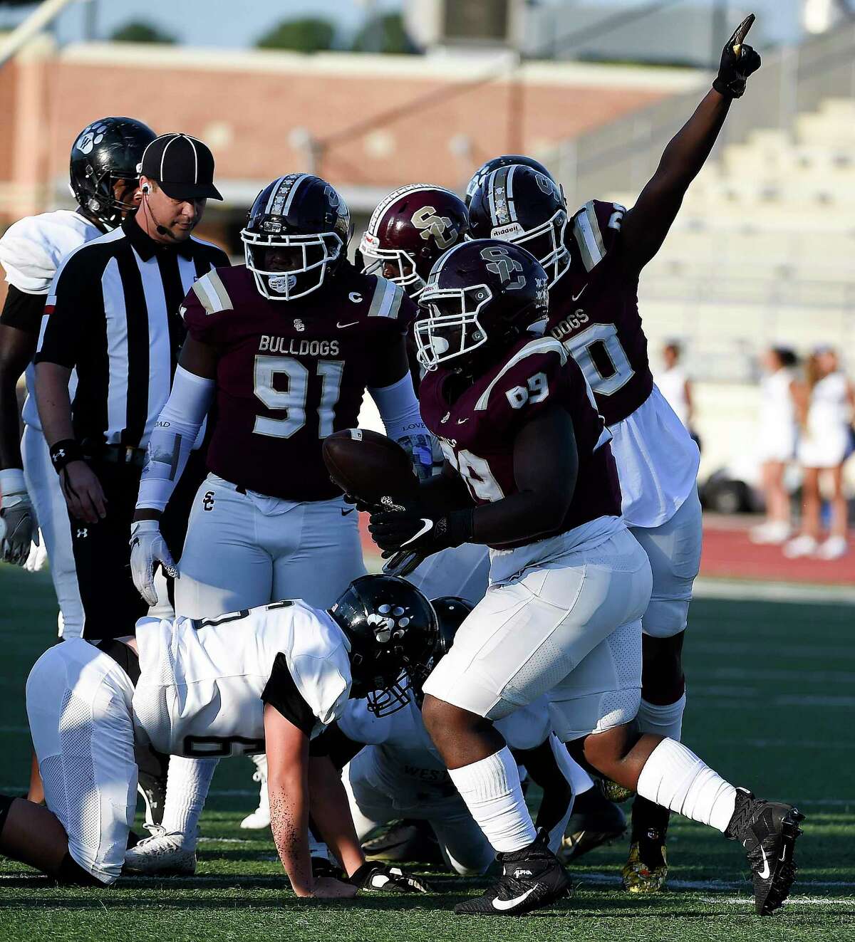 Summer Creek defensive lineman Caden Rain, right, signals possession after defensive lineman Amantie Lockhart, second from right, recovered the fumble of Westside wide receiver Josiah Scott during the first half of a high school football game, Saturday, Sept. 18, 2021, in Humble.