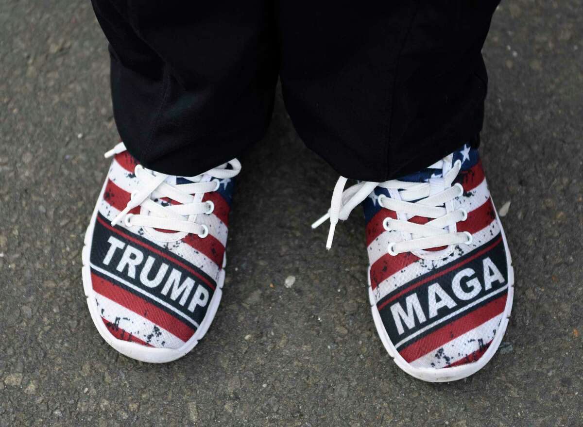 A woman sports Trump shoes at the Trump 2020/Back the Blue rally in Greenwich, Conn. Sunday, Oct. 25, 2020. Hundreds of Donald Trump supporters rallied together to how support for the president's re-election bid in the Island Beach parking lot before caravaning north together on I-95.