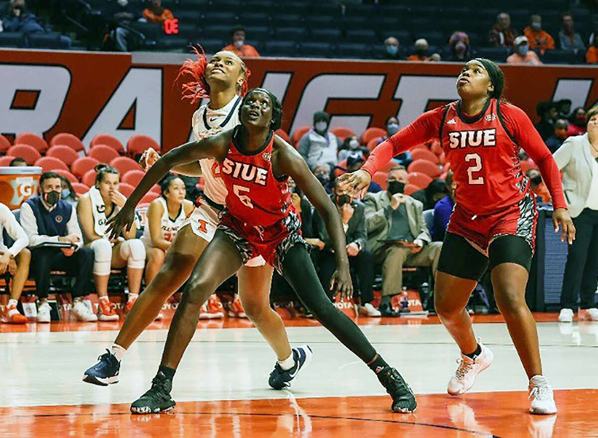 SIUE's Ajulu Thatha (5) blocks out Lyric Robins of Illinois as they battle for a rebound Thursday night in Champaign. Also shown is SIUE's Prima Chellis (2).